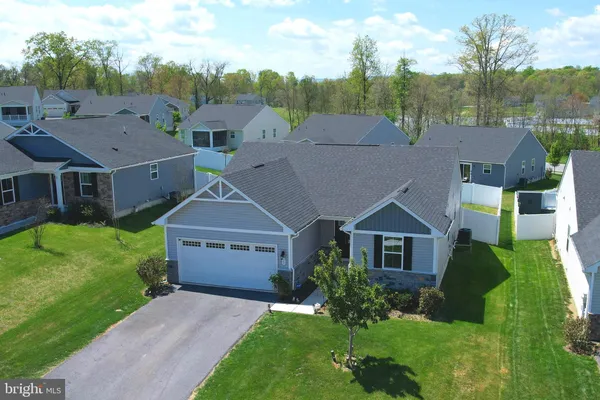 a aerial view of a house next to a big yard and large trees