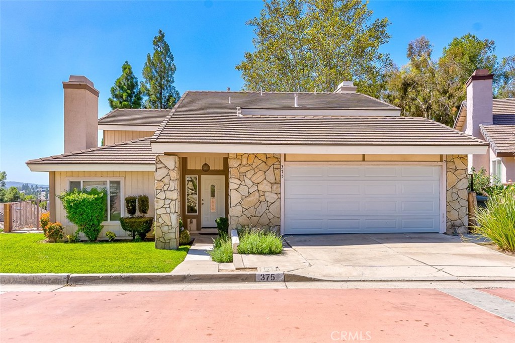 a front view of a house with a garden and plants
