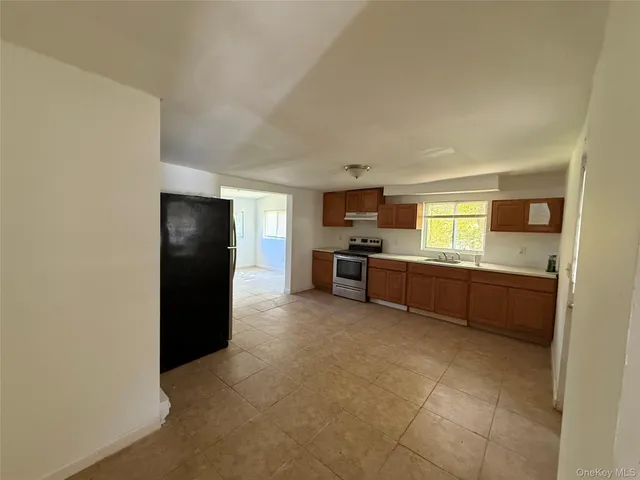 a large kitchen with a refrigerator and a stove