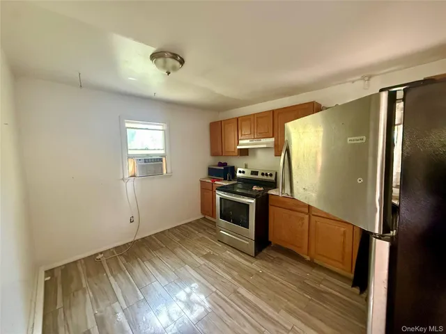 a kitchen with granite countertop a refrigerator stove and sink