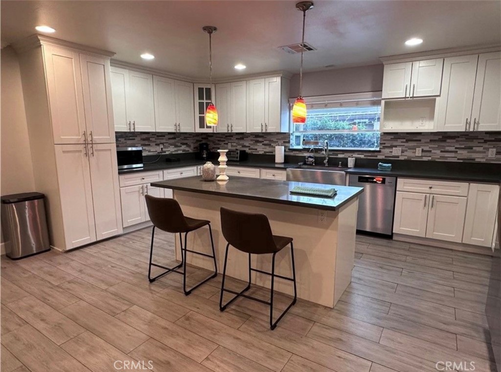 412 Magellan Road Arcadia, CA 91007 - Photo 5 of 15 a kitchen with stainless steel appliances granite countertop a table chairs sink refrigerator and microwave