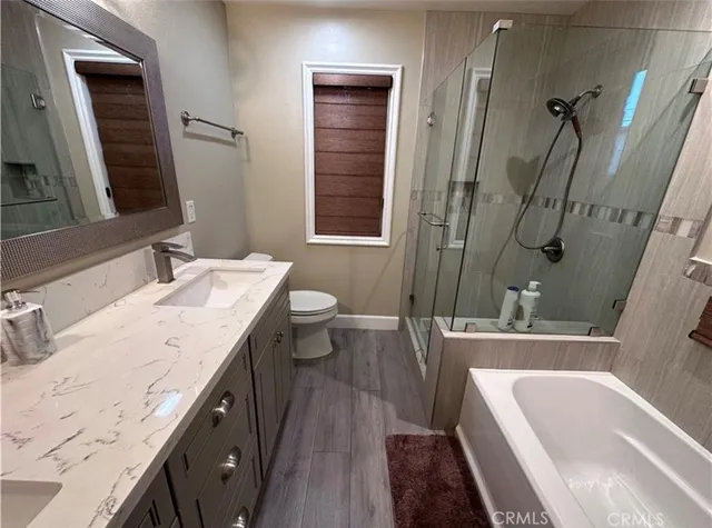 a bathroom with a granite countertop tub sink and mirror