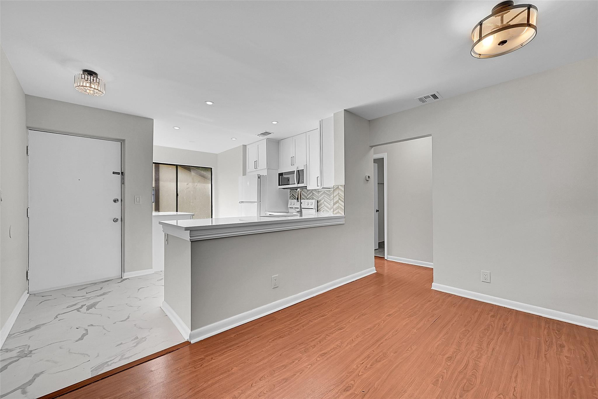 a kitchen with granite countertop a refrigerator and a stove top oven