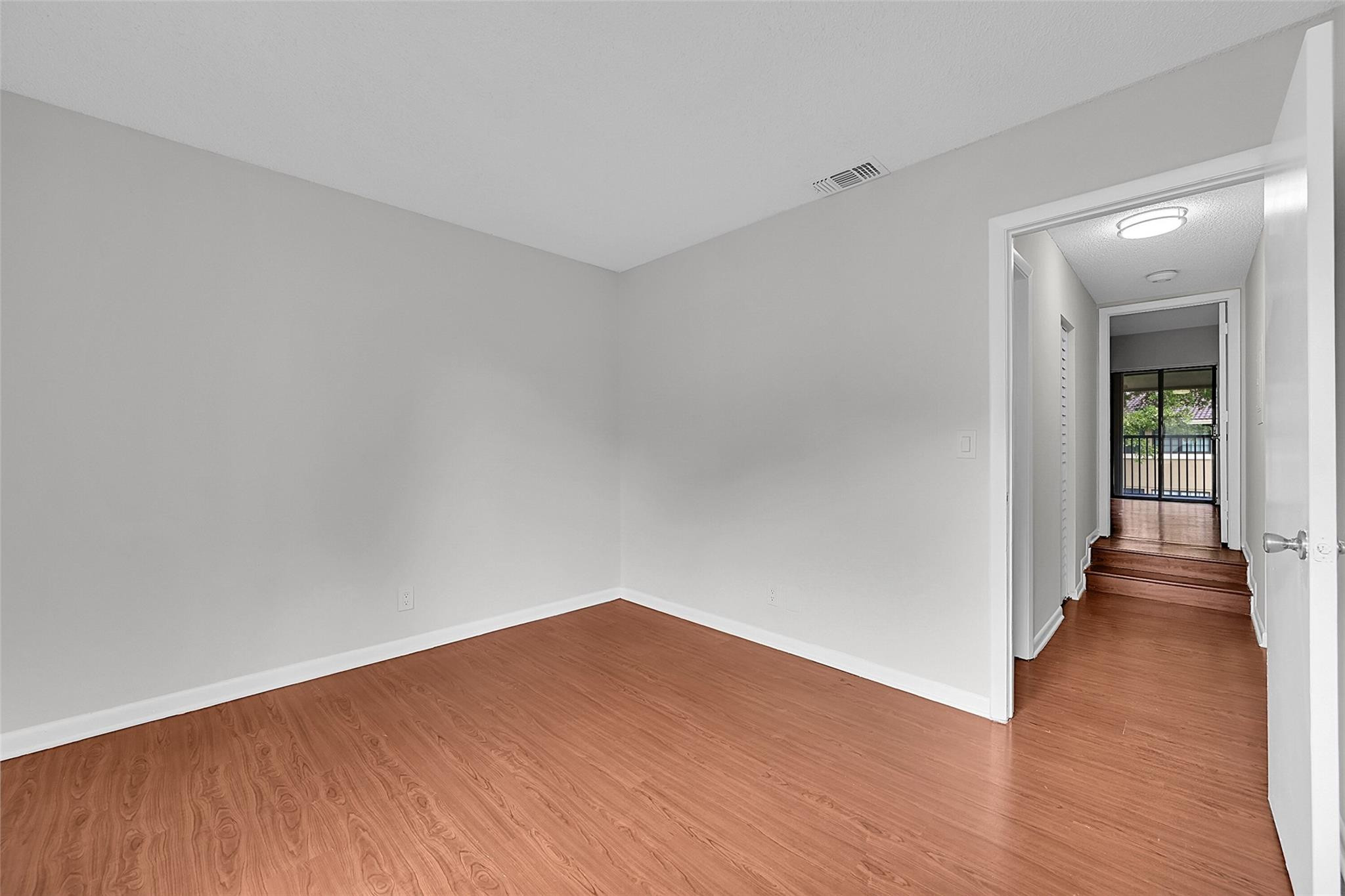 2578 Riverside Drive, Unit 421 Coral Springs, FL 33065 - Photo 19 of 29 an empty room with wooden floor and windows
