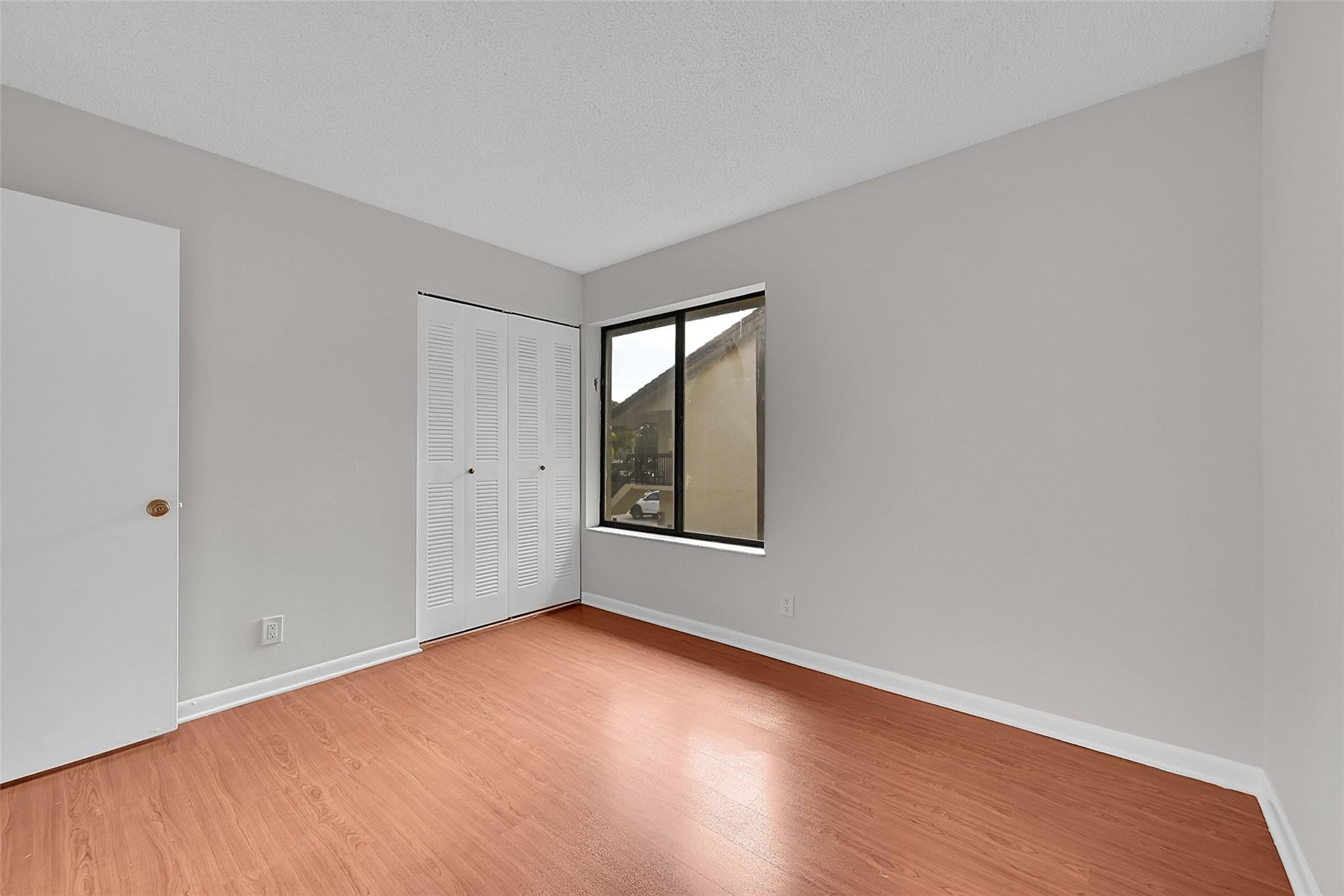 2578 Riverside Drive, Unit 421 Coral Springs, FL 33065 - Photo 20 of 29 a view of an empty room with wooden floor and a window