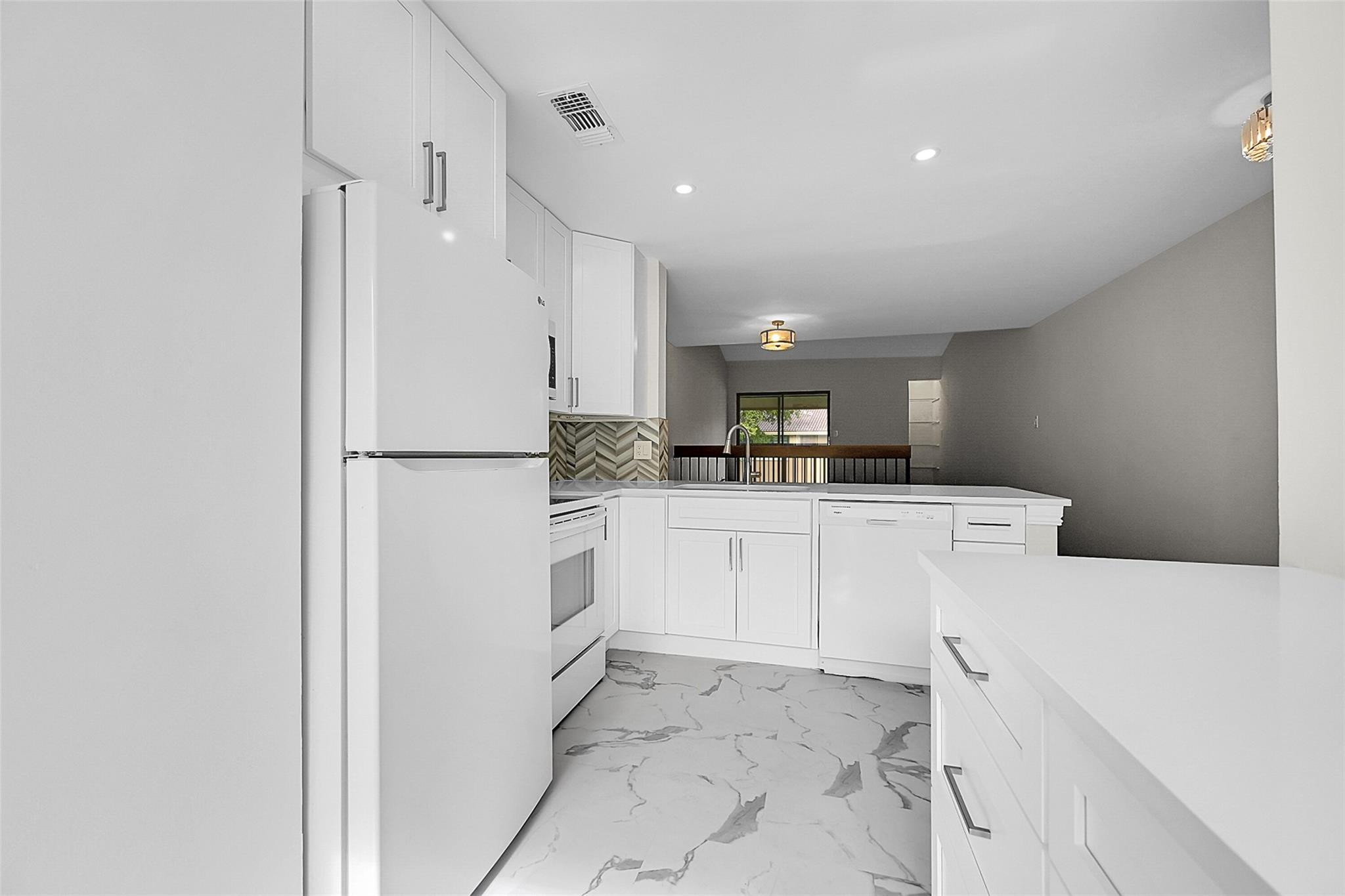 2578 Riverside Drive, Unit 421 Coral Springs, FL 33065 - Photo 3 of 29 a kitchen with white cabinets and refrigerator