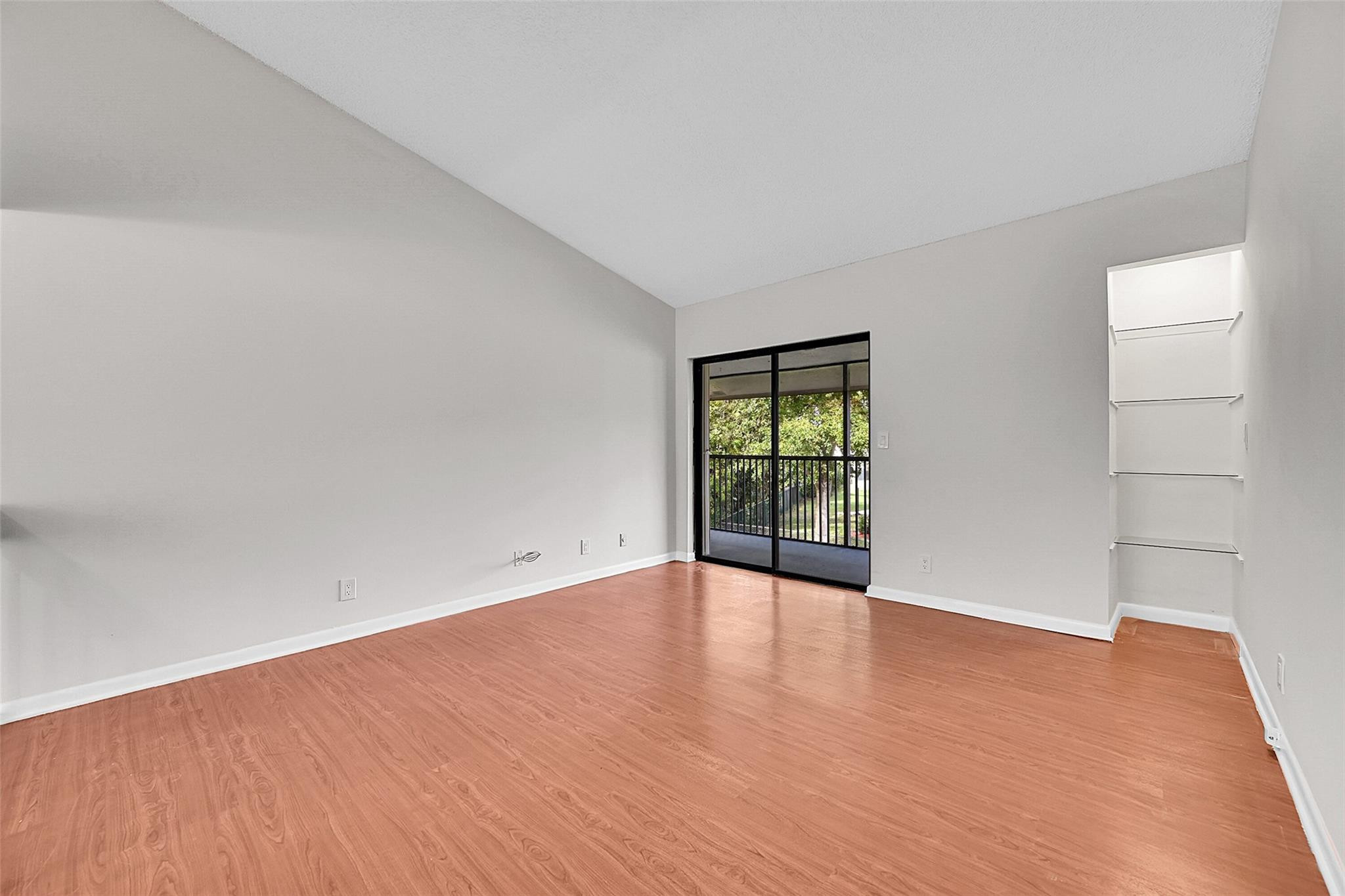 2578 Riverside Drive, Unit 421 Coral Springs, FL 33065 - Photo 7 of 29 a view of an empty room with wooden floor and a window
