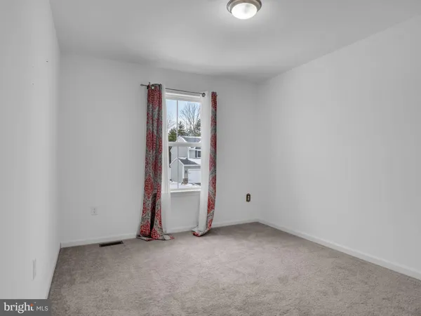 an empty room with closet and a ceiling fan