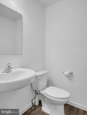 a view of kitchen with refrigerator and white cabinets