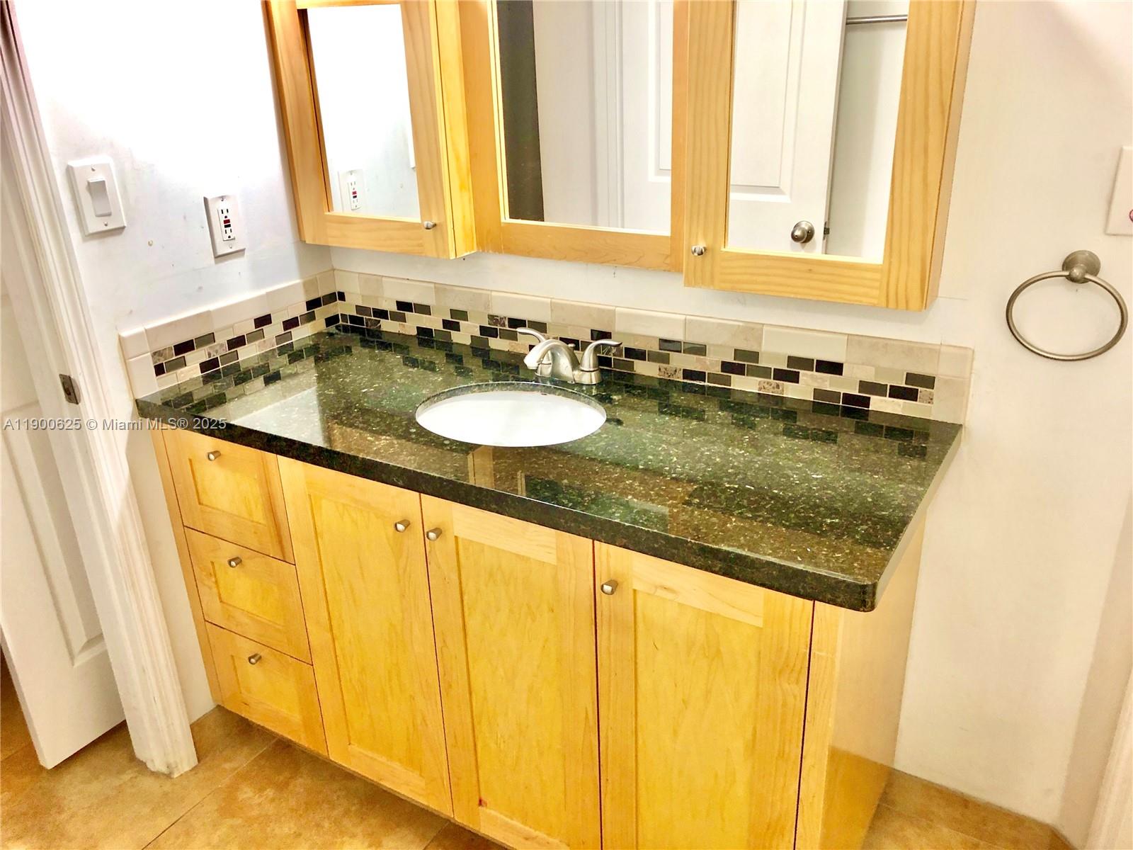 10440 Southwest 156th Court, Unit 712 Miami, FL 33196 - Photo 7 of 11 a bathroom with a granite countertop sink and a mirror