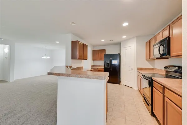 a kitchen with stainless steel appliances granite countertop a stove top oven a sink dishwasher and a microwave oven with white cabinets