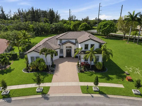 a front view of a house with a garden and plants