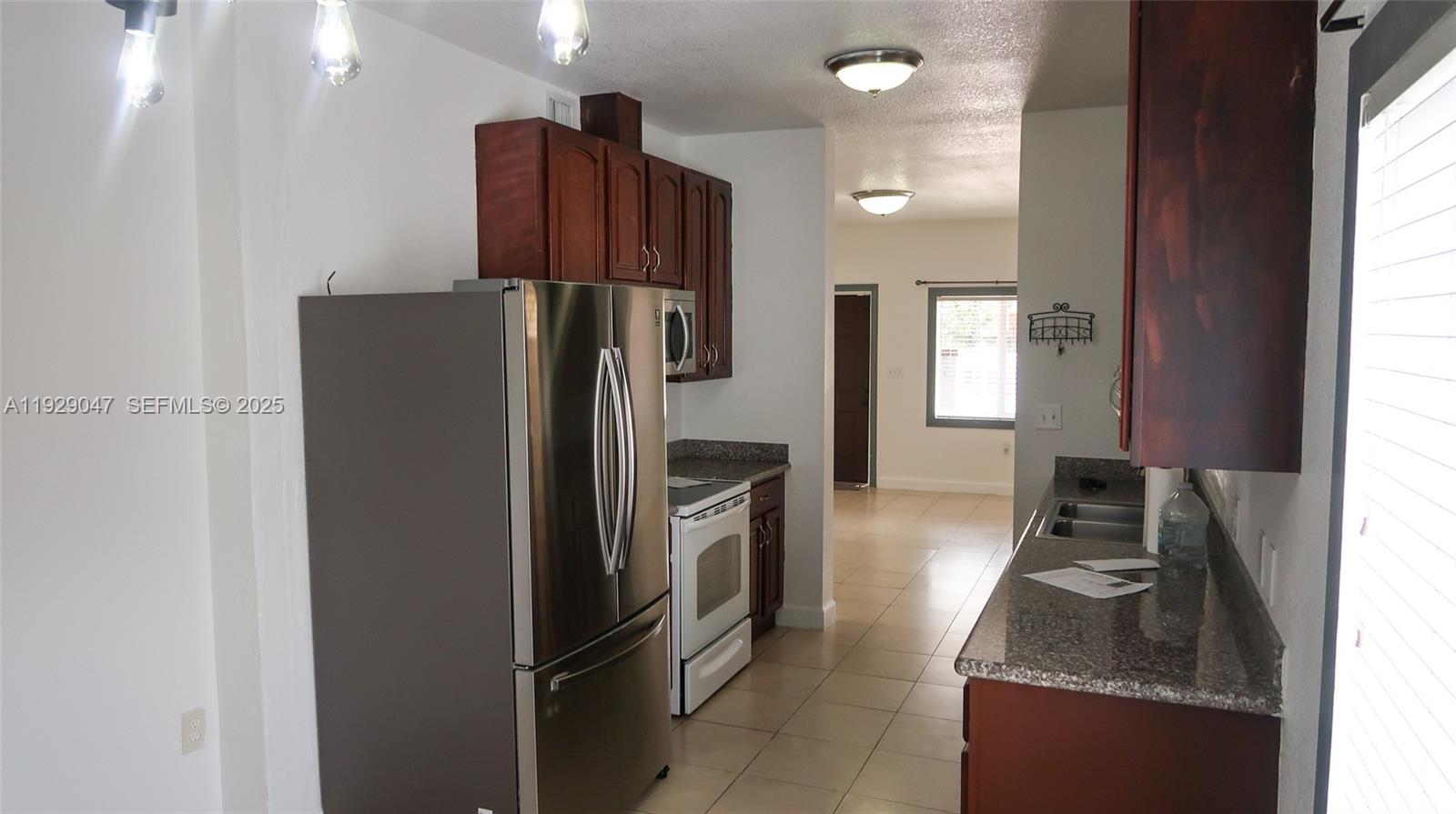 3109 Northwest 64th Street Miami, FL 33147 - Photo 11 of 38 a kitchen with a refrigerator and a stove