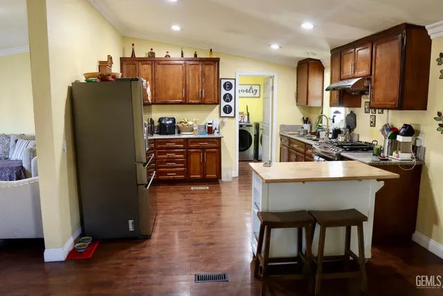 a kitchen with stainless steel appliances granite countertop a refrigerator stove microwave and sink