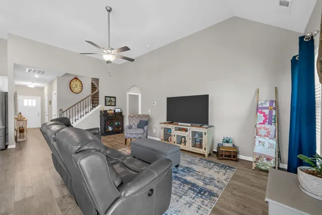 a living room with furniture a flat screen tv and a fireplace