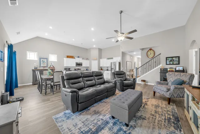 a living room with furniture kitchen view and a chandelier