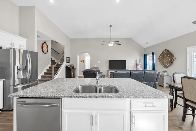 a kitchen with kitchen island granite countertop a table and chairs in it
