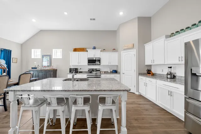 a large kitchen with granite countertop a sink counter top space and stainless steel appliances