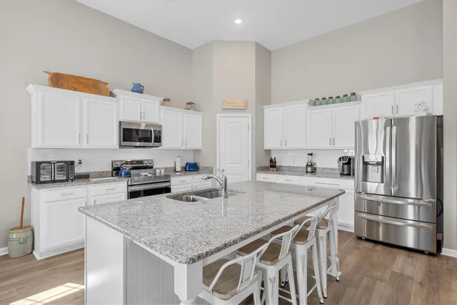 a kitchen with granite countertop a center island stainless steel appliances and cabinets