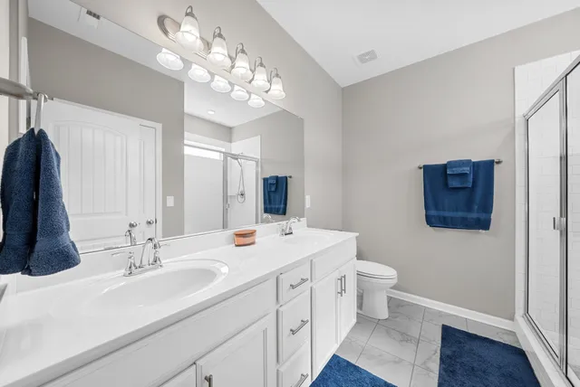 a bathroom with a sink a toilet and a large mirror