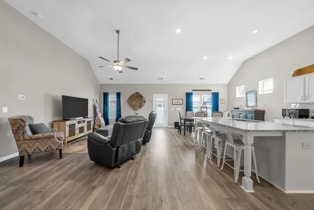 a living room with furniture a flat screen tv and a fireplace