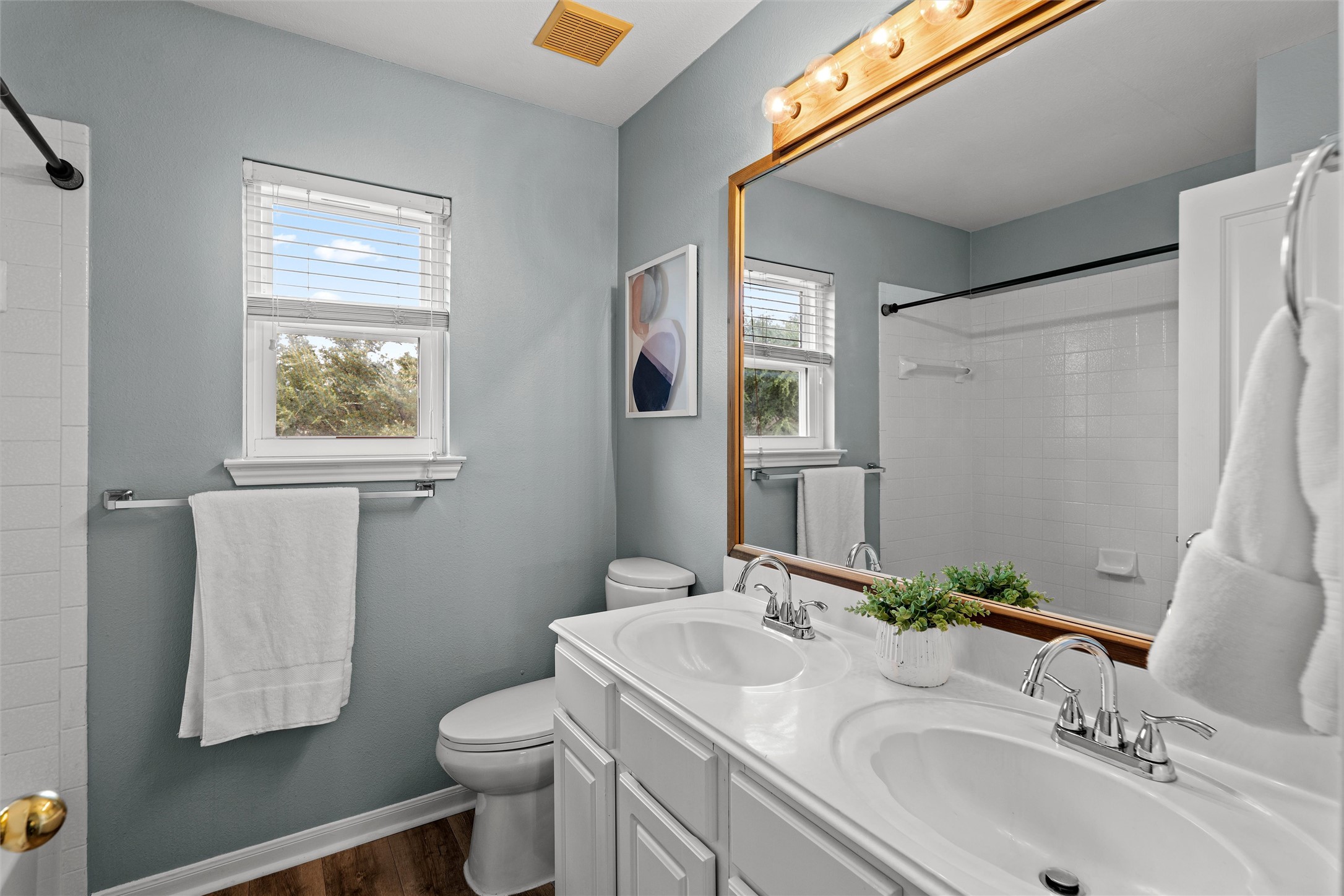 7000 Colberg Court Austin, TX 78749 - Photo 26 of 40 A well-appointed second bathroom features a double vanity and a shower-tub combination, illuminated by natural light.