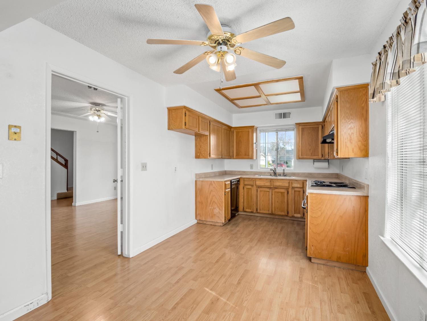 272 North Caesar Avenue Clovis, CA 93612 - Photo 11 of 34 a large kitchen with a wooden floor and stainless steel appliances