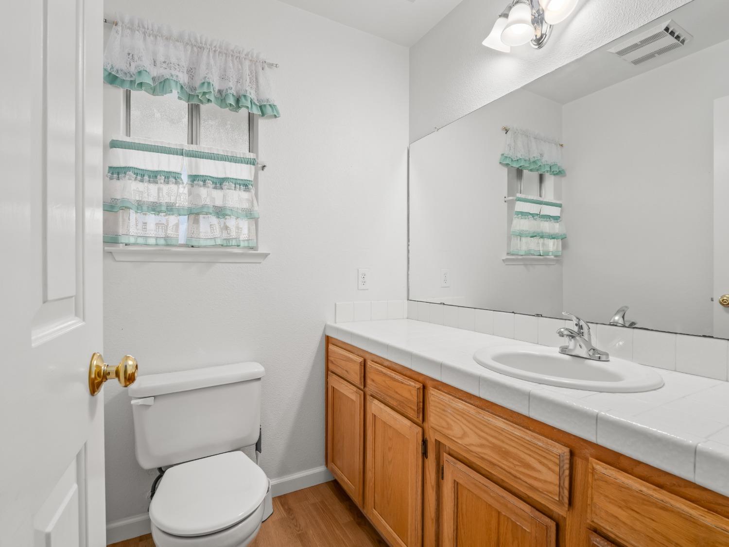 272 North Caesar Avenue Clovis, CA 93612 - Photo 6 of 34 a bathroom with a granite countertop toilet sink and mirror