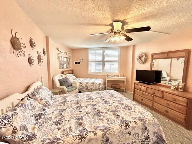 a bedroom with a large bed and a flat tv screen on dresser