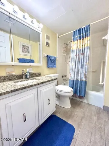 a bathroom with a granite countertop sink mirror vanity and toilet
