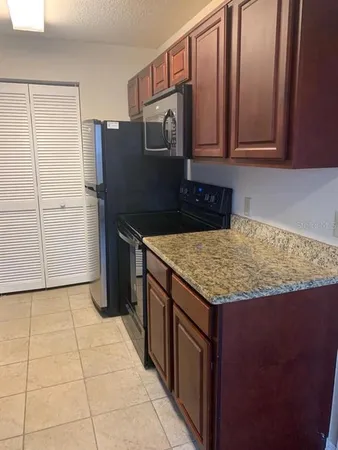 a kitchen with granite countertop a stove and a microwave