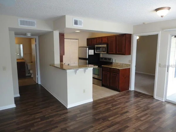 a kitchen with stainless steel appliances kitchen island wooden cabinets and granite counter tops