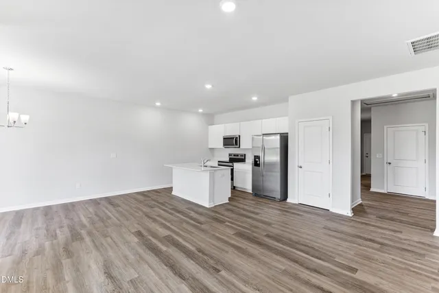 a kitchen with a sink a window and wooden floor
