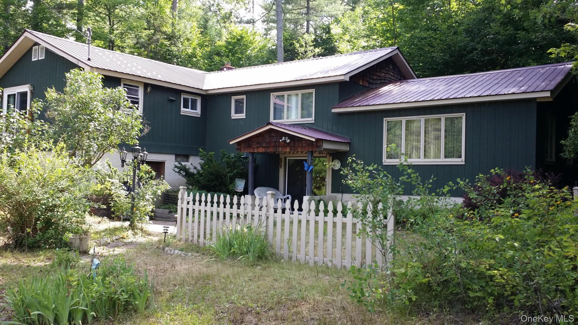 226 Park Road Johnsburg, NY 12843 - Photo 2 of 10 a front view of a house with a garden