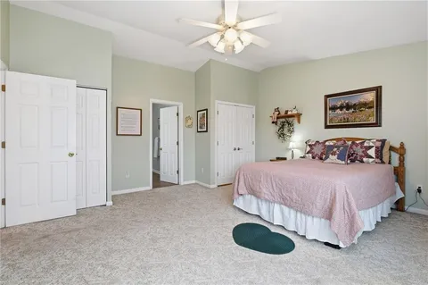 a spacious bedroom with a bed and lamp