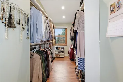 a view of walk in closet with clothes and shoes
