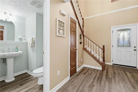 a view of a hallway with wooden floor and staircase