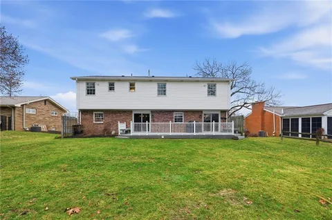 a view of a house with a big yard and large trees