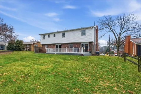a view of a house with a big yard plants and large trees
