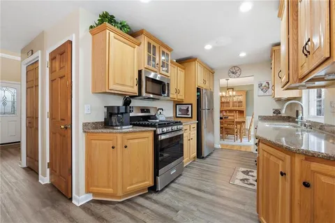 a kitchen with stainless steel appliances granite countertop a refrigerator a stove and a sink