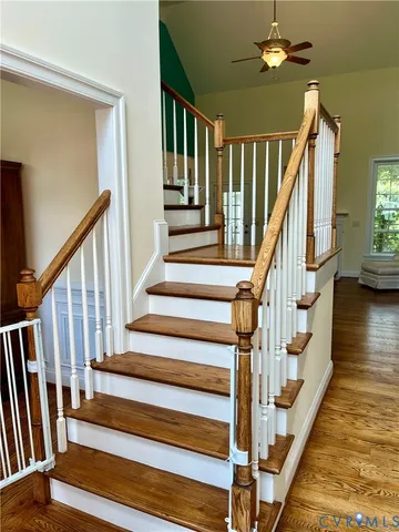 a view of staircase with lots of frames on wall and wooden floor