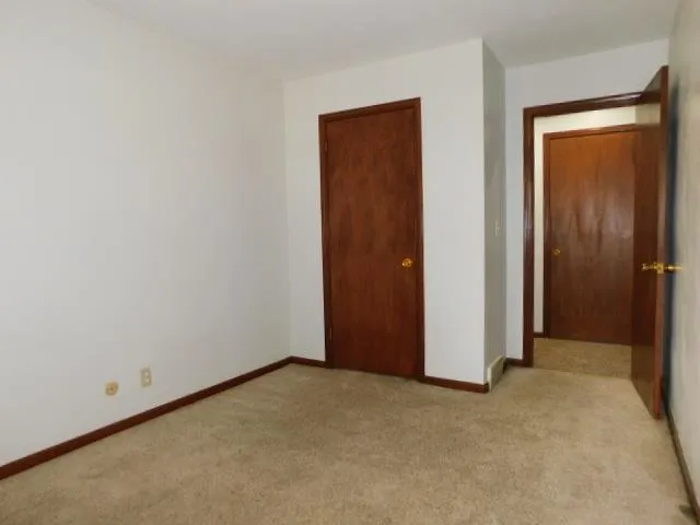 an empty room with closet and a window