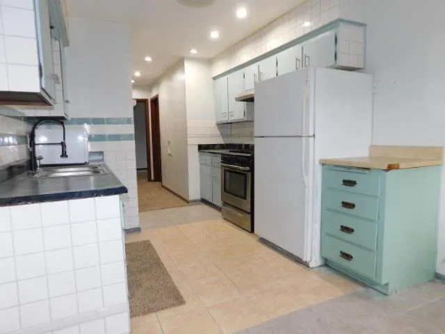 a kitchen with stainless steel appliances a refrigerator sink and cabinets