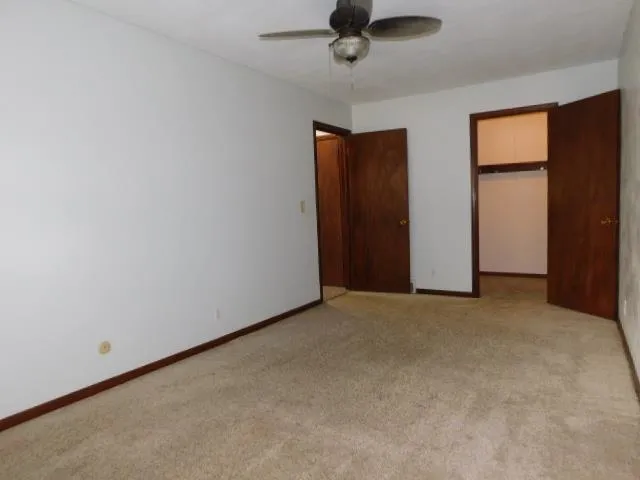 an empty room with a window and a ceiling fan