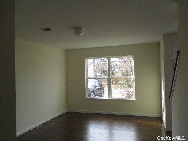 655 Bourdois Avenue Bellport, NY 11713 - Photo 11 of 28 an empty room with wooden floor and windows