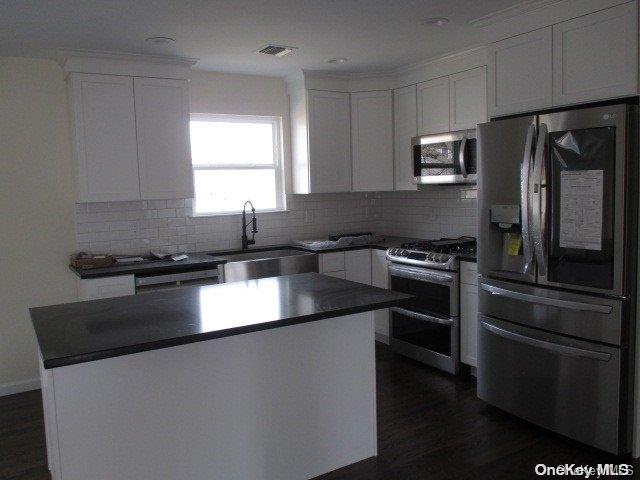 655 Bourdois Avenue Bellport, NY 11713 - Photo 24 of 28 a kitchen with granite countertop a refrigerator stove and sink