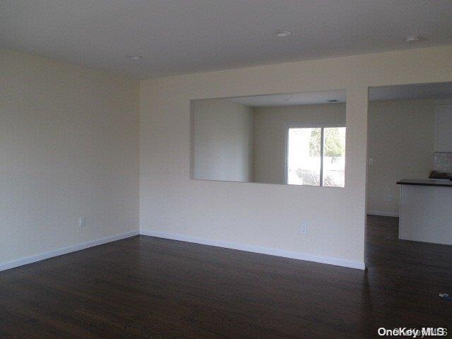655 Bourdois Avenue Bellport, NY 11713 - Photo 7 of 28 a view of an empty room with wooden floor and a window