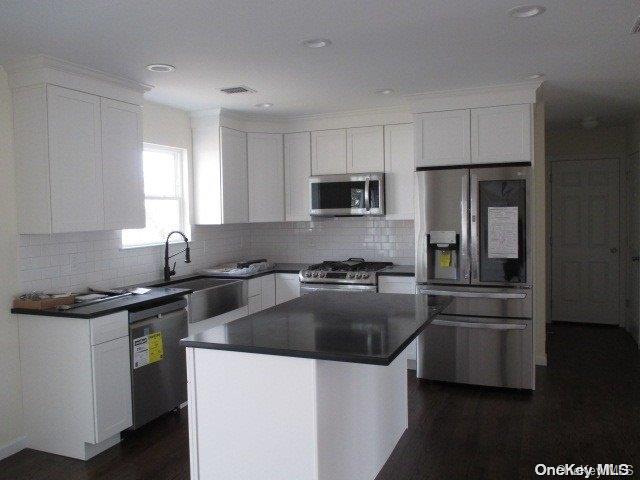 655 Bourdois Avenue Bellport, NY 11713 - Photo 10 of 28 a kitchen with stainless steel appliances a sink a stove a microwave a refrigerator a sink and cabinets