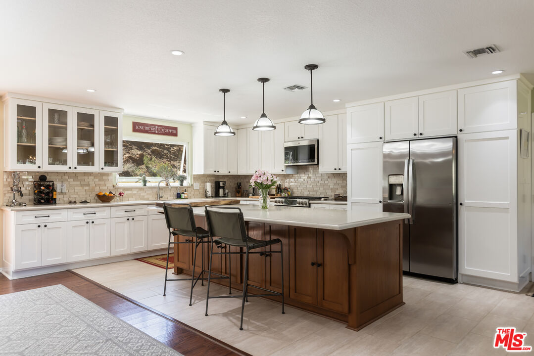 a kitchen with refrigerator and chairs