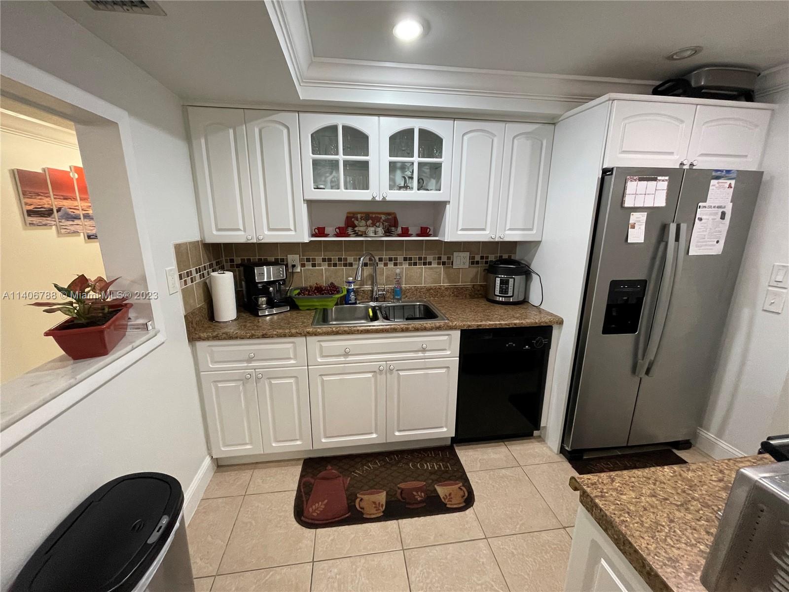 6861 Southwest 147th Avenue, Unit 2G Miami, FL 33193 - Photo 12 of 34 a kitchen with a refrigerator sink and cabinets
